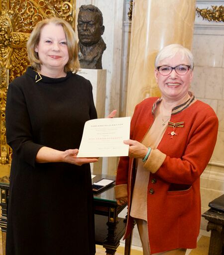 Die Senatorin überreicht Antonia Peters die Urkunde zum Bundesverdienstkreuz